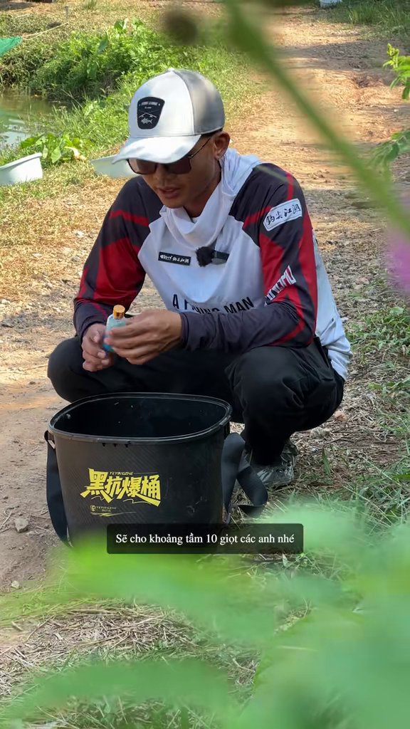 Cao Thiện đang nhỏ hương liệu từ chai vào xô mồi câu cá